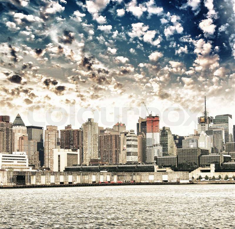 Manhattan. Beautiful sky colors over New York City skyscrapers, view from Hudson river, stock photo