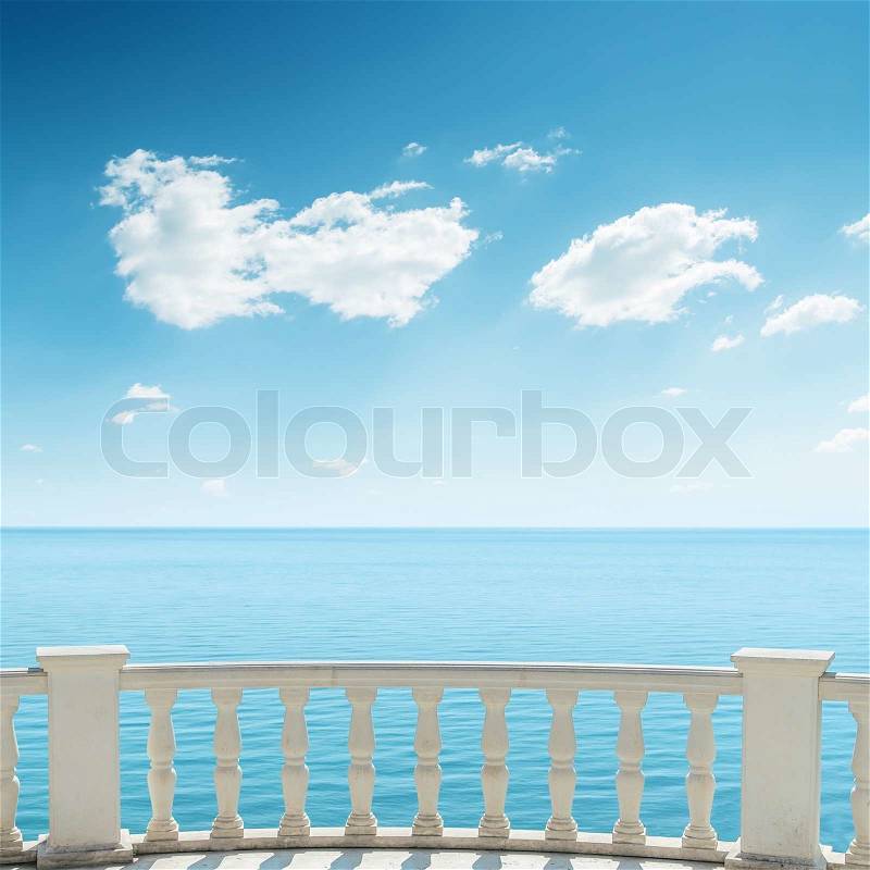 View to the sea from a balcony under cloudy sky, stock photo