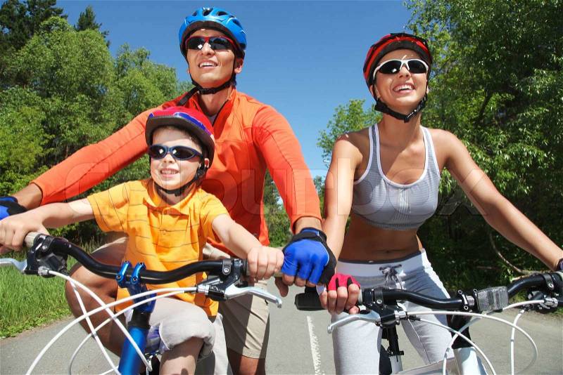 Portrait of happy family on bicycles in the park, stock photo