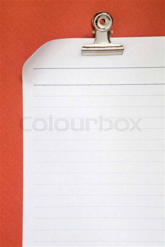 Blank white paper on red background with clip, stock photo