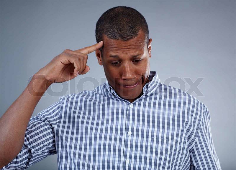 Image of young African man keeping his forefinger by head in isolation, stock photo