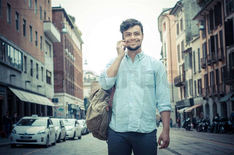 Stylish man in the street at the phone in the city, stock photo
