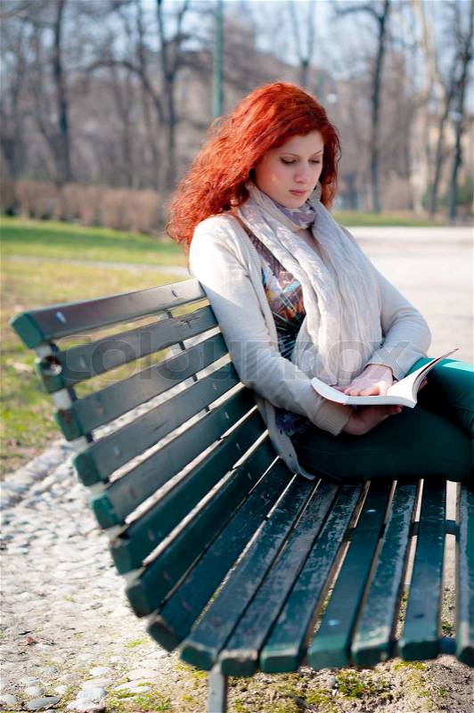 Beautiful red head young woman reading book, stock photo