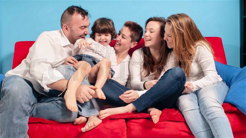 Happy family on the couch in the living room, stock photo