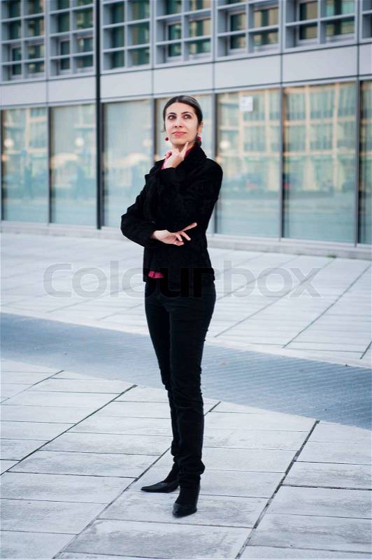 Thinker business girl in front of modern building, stock photo