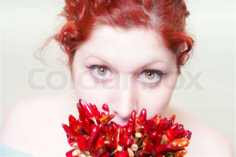 Beautiful red hair and lips girl with red chillies on white background, stock photo
