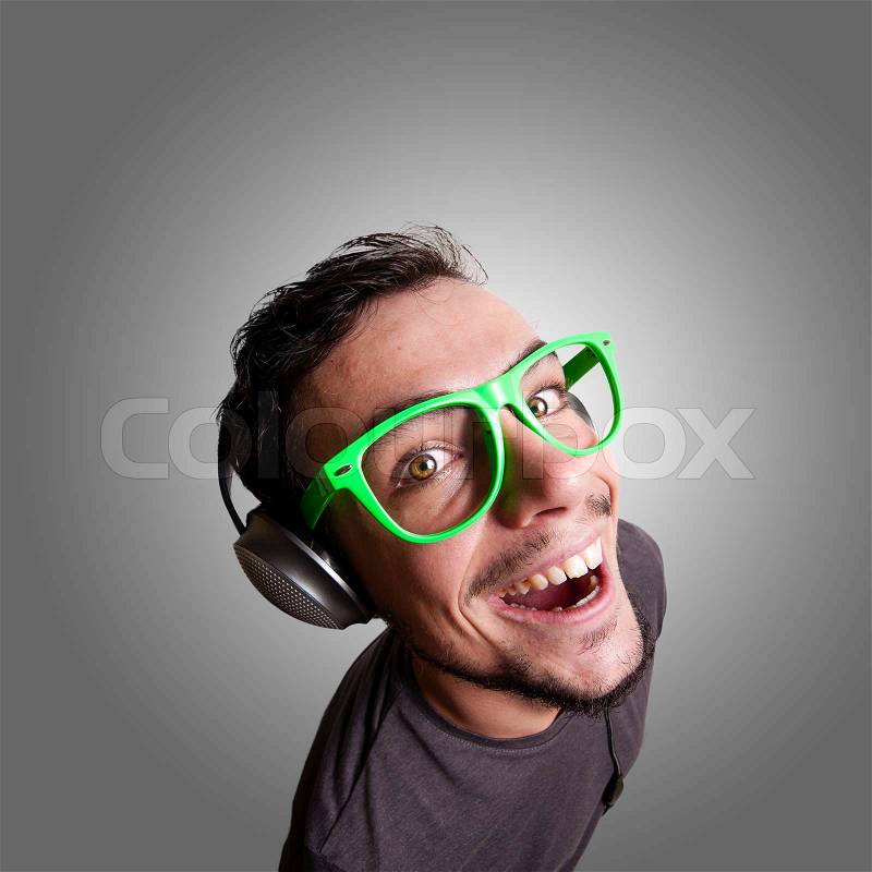 Crazy guy listening to music with green eyeglasses, stock photo