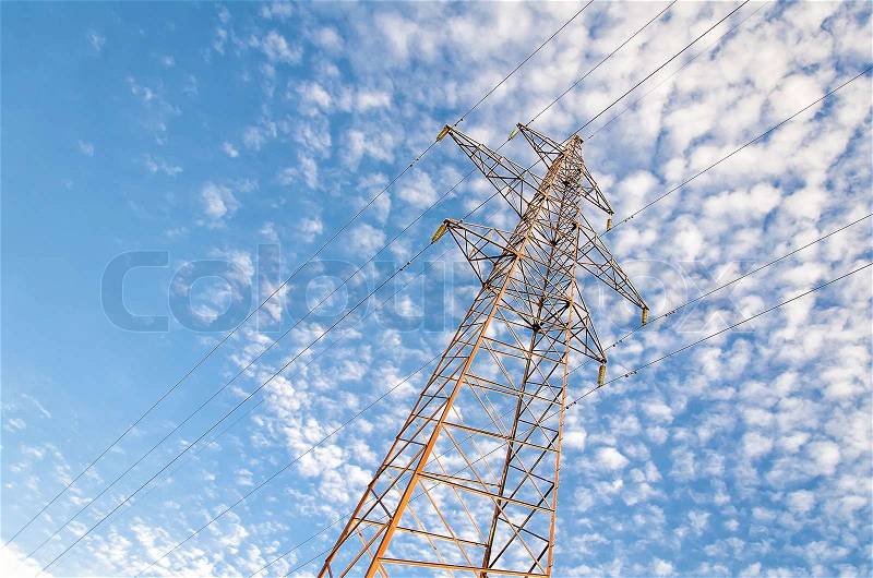 High-voltage power tower over blue sky, stock photo