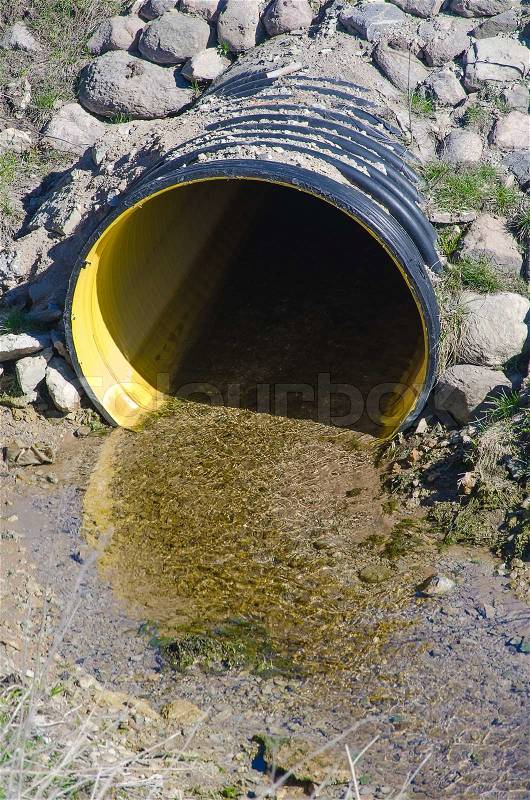 Waste water pipe polluting environment, stock photo