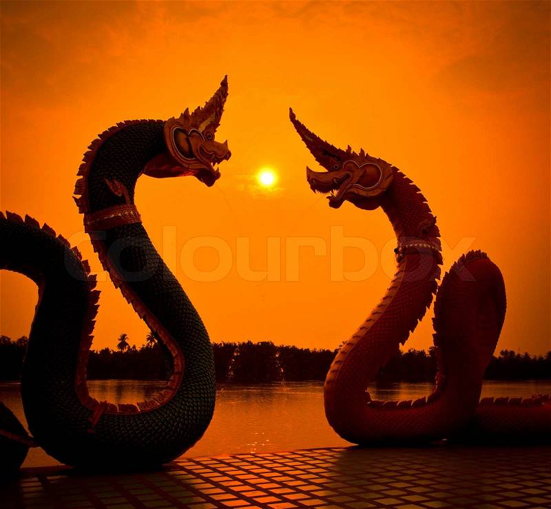 Silhouettes dragon and Naga statue protecting Thai temple, stock photo