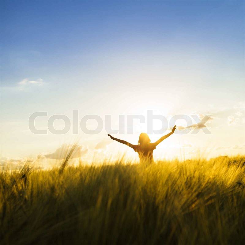 Teenage girl enjoy with sunshine in wheat field, stock photo