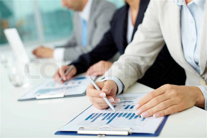 Business people sitting at the table and analyzing graphs, stock photo