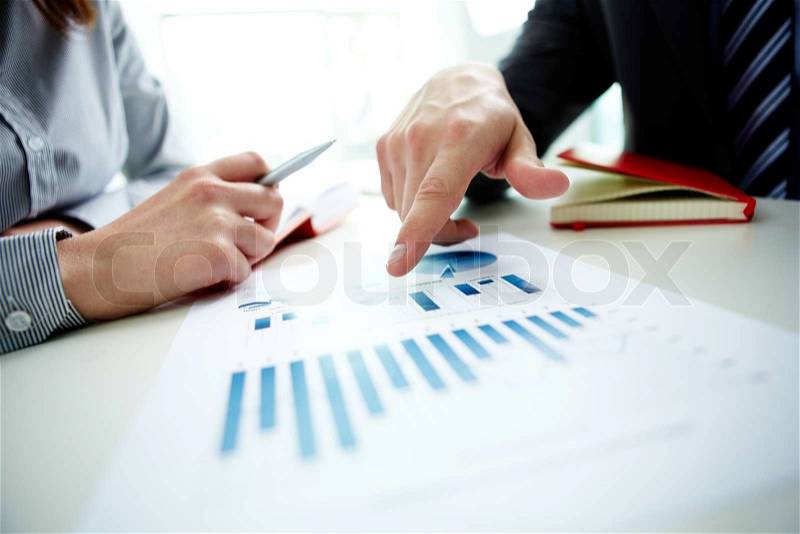 Image of male hand pointing at business document during discussion at meeting, stock photo