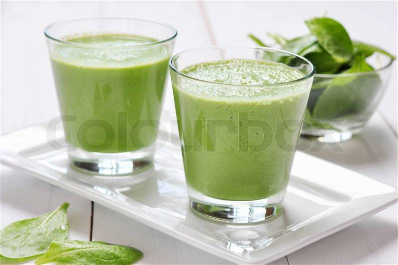 Spinach smoothies in glass on a wooden background, stock photo