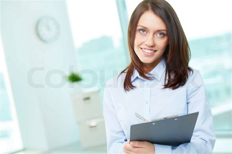Copy-spaced portrait of a lovely business intern holding clipboard, stock photo