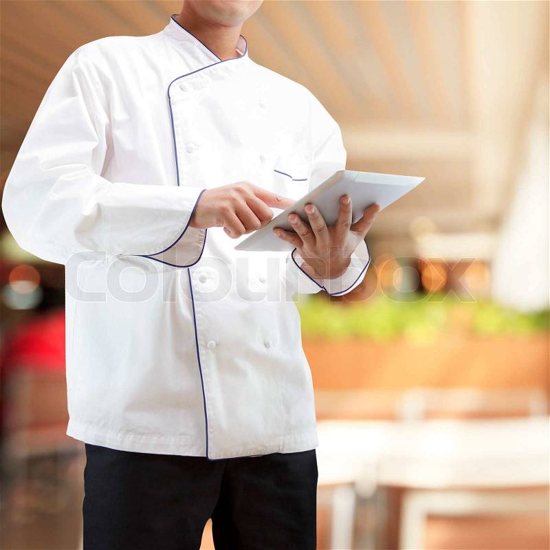 Chef using digital tablet in restaurants, stock photo