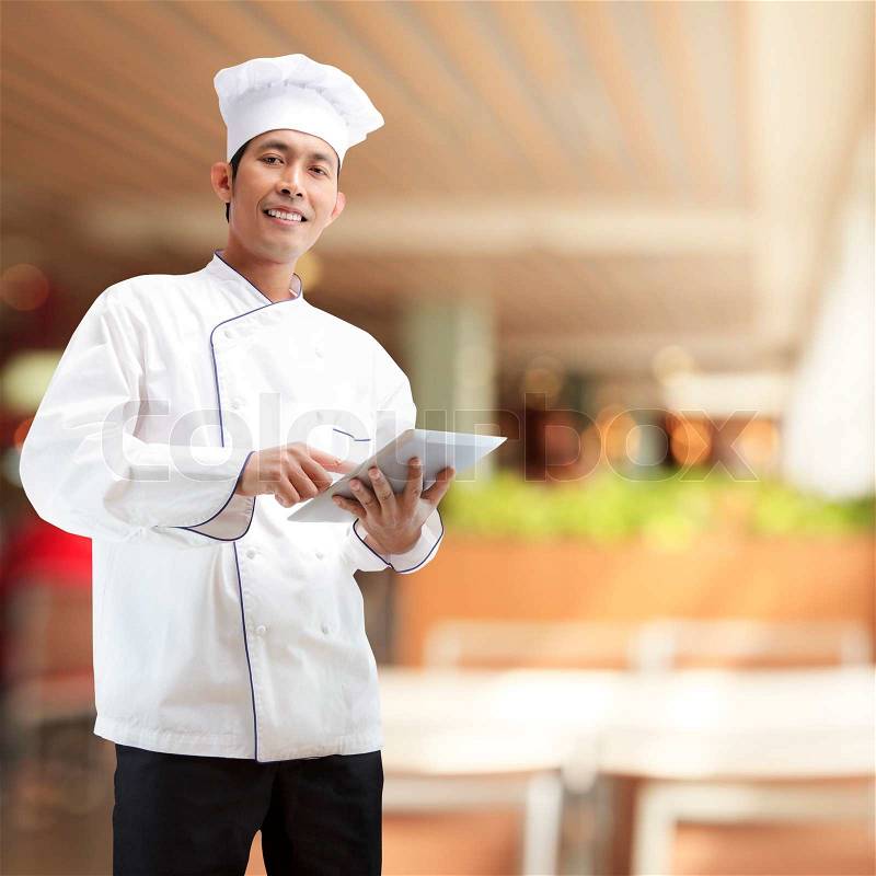 Chef using digital tablet in restaurants, stock photo