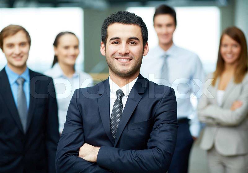 Group of friendly businesspeople with male leader in front, stock photo