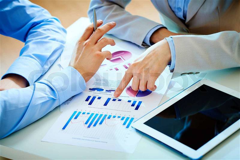 Close-up of female hand pointing at business document while explaining chart, stock photo