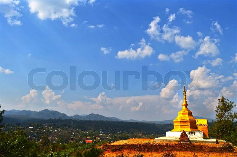 Golden pagoda on country hill above village, stock photo