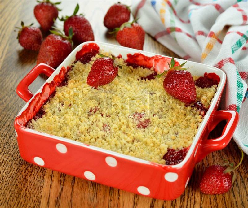 Strawberry crumble on a brown table, stock photo