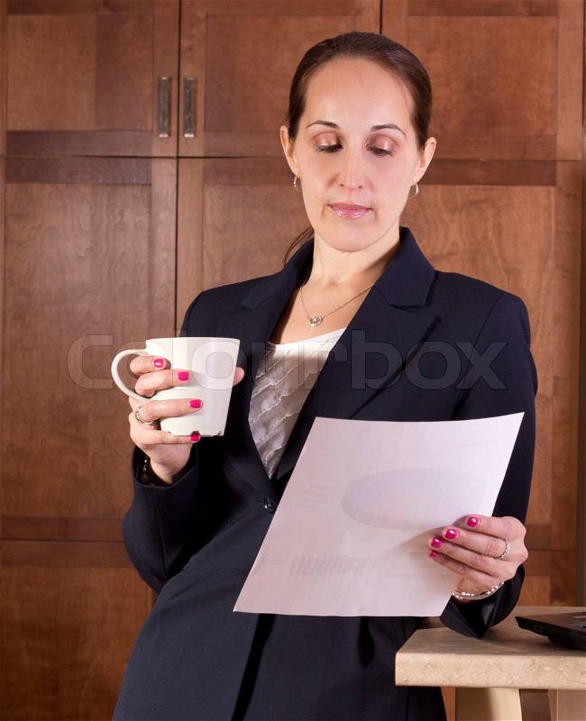 Business woman drinks coffee and reads a document, stock photo
