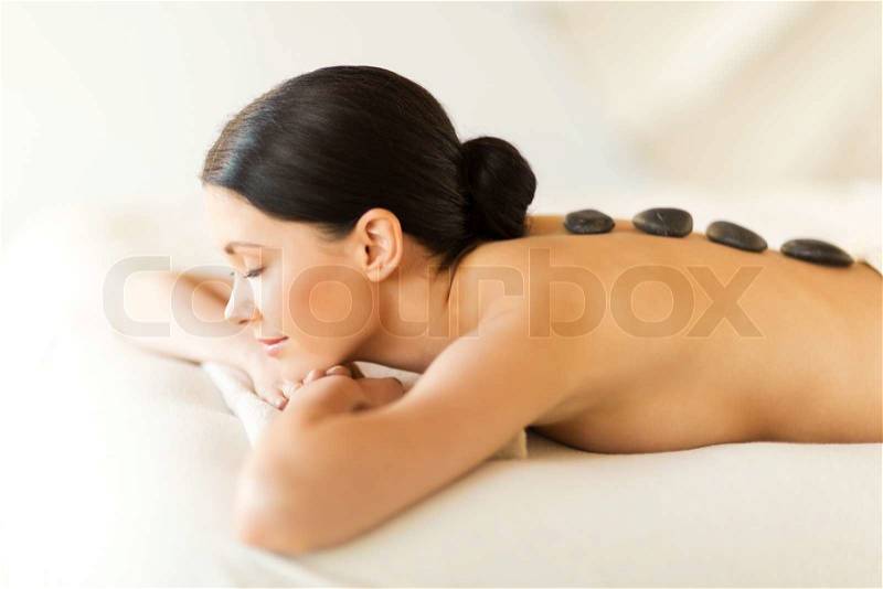Picture of woman in spa salon with hot stones, stock photo