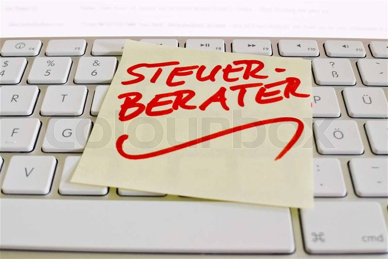 A sticky note on the keyboard of a computer is a reminder: accountants, stock photo