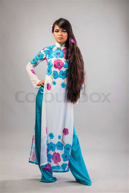 Beautiful asian woman wears a national dress isolated on a grey backround, stock photo