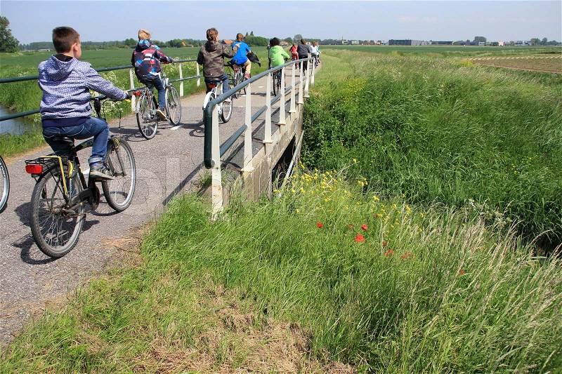 The group of bikers, youth, cycling over the bridge and going to school in the summer, a nice trip, stock photo