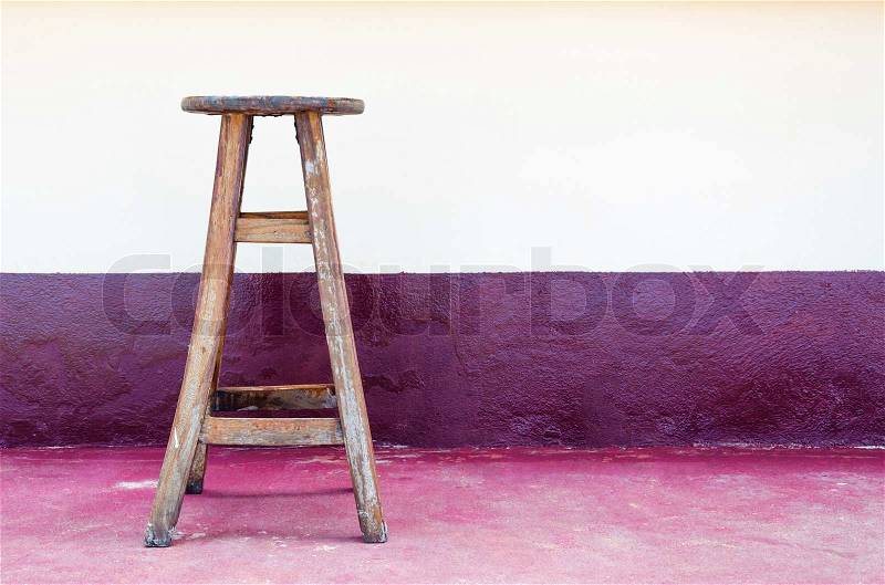 Old wood chair against wall background, stock photo