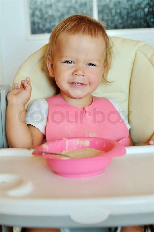 Happy eating baby girl, stock photo