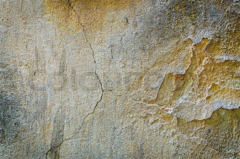 Background texture of and old cracking wall with falling concrete parts, stock photo
