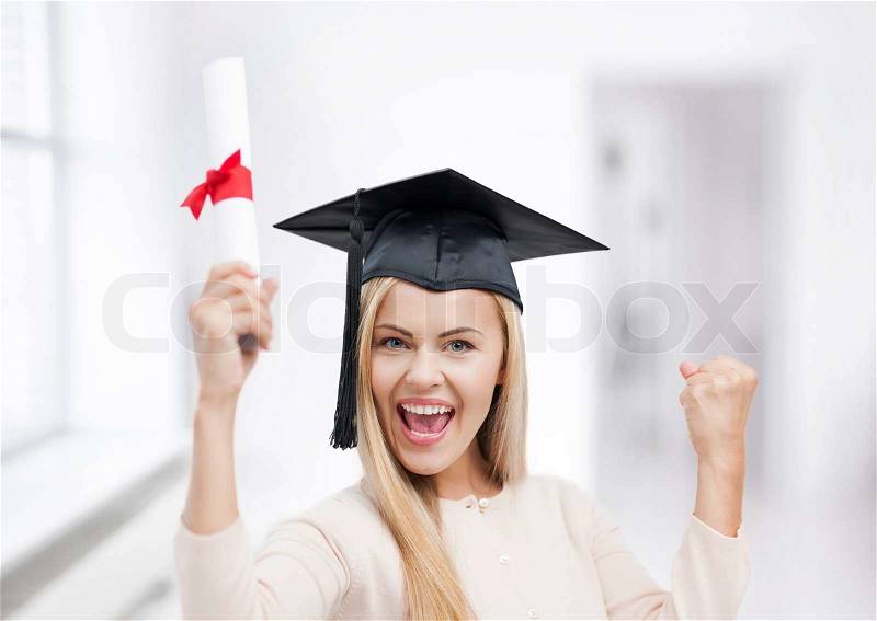 Happy student in graduation cap with certificate, stock photo