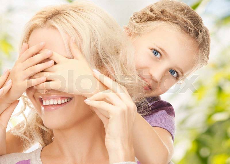 Picture of mother and daughter making a joke or playing hide and seek, stock photo