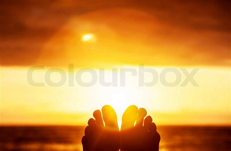 Peaceful beautiful orange sunset, body part, persons toes, carefree lifestyle, summer vacation, harmony and freedom concept, stock photo