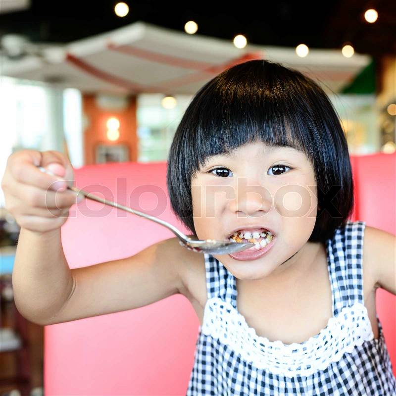 Girl eating fish finger, stock photo