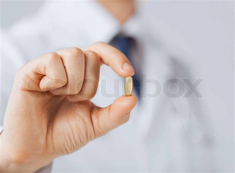 Picture of doctor hand showing one capsule, stock photo