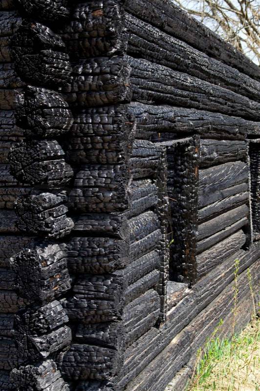 Burnt wooden house on the street, close-up, stock photo
