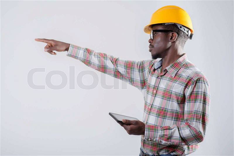 African-American man in a helmet with a digital tablet, stock photo