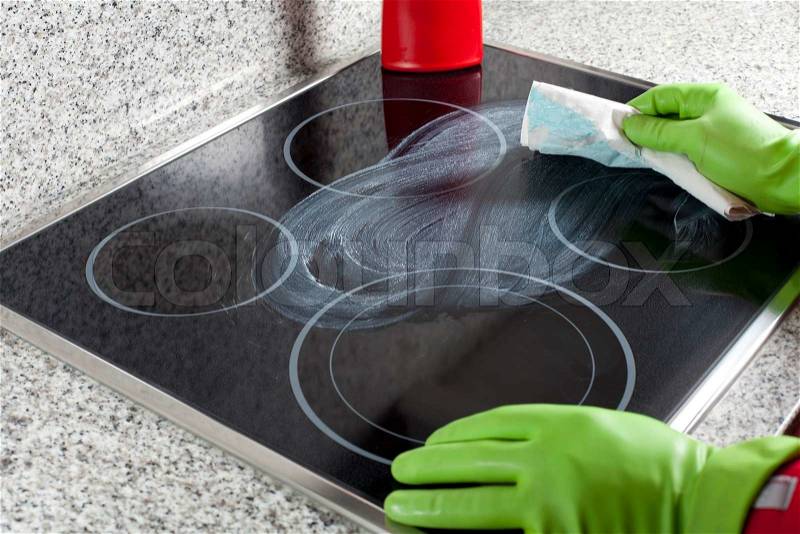 Cleaning the hob with special liquid, stock photo