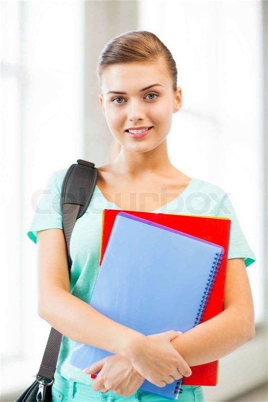Happy student girl with school bag and notebooks, stock photo