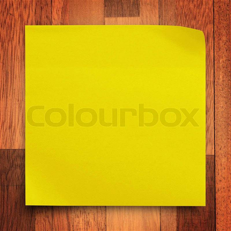 Yellow sticker paper note on wood wall background, stock photo