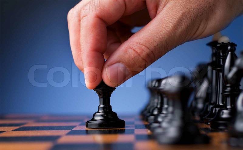 Chess game, chess player makes a move the black pawn forward, stock photo