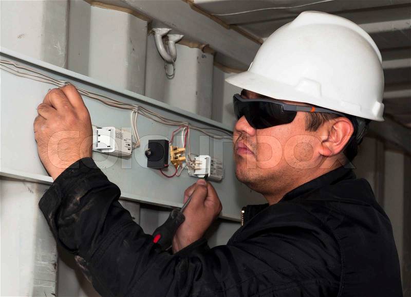 The electrician establishes an electrical wiring Installation of equipment on production, stock photo