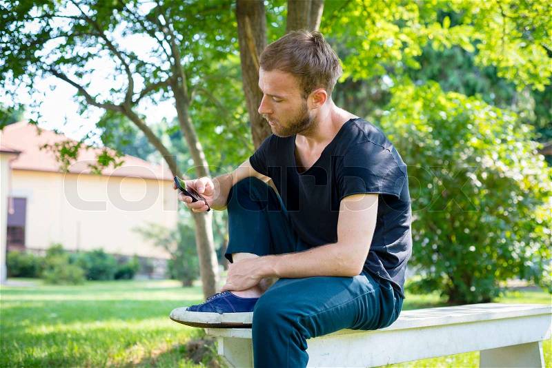 Hipster modern stylish blonde man with phone in daily life, stock photo