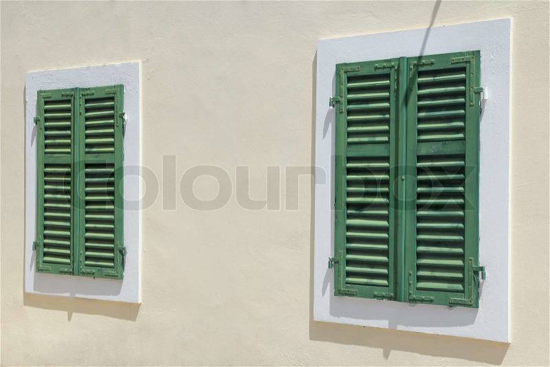 Green vintage windows with shutters over white wall, stock photo