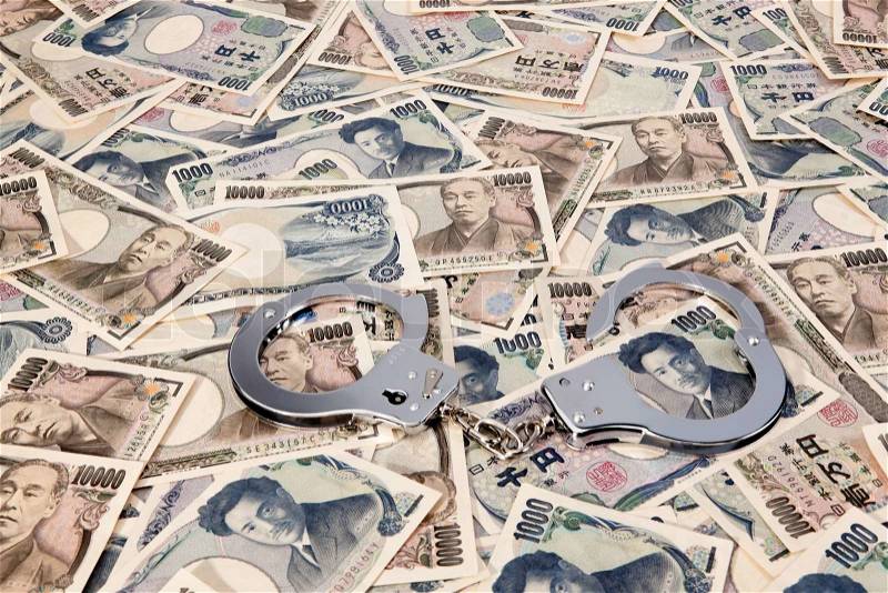 Yen banknotes, currency from japan with handcuffs. crime in the economy, stock photo