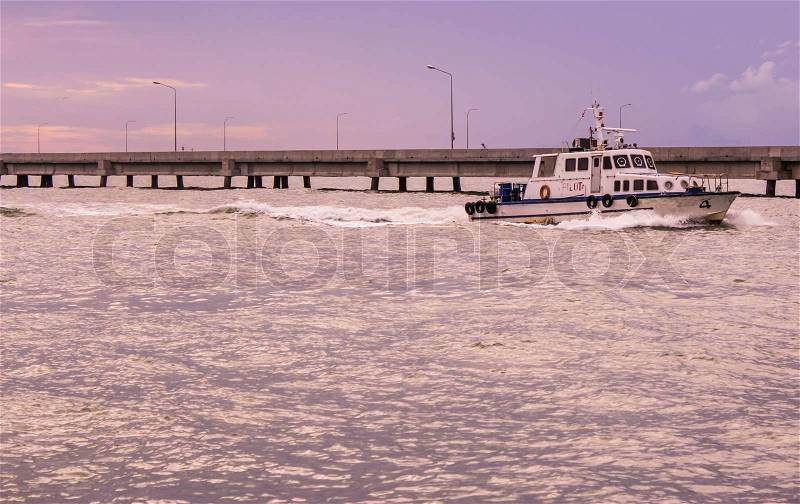 A small boat accompanies the ocean ferry to sail between the islands, stock photo