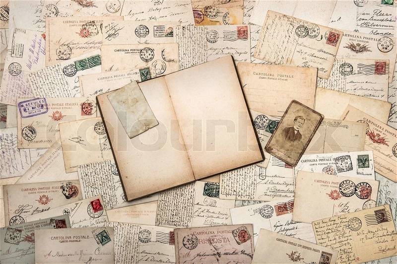 Nostalgic vintage background with old handwritten postcards and open empty book, stock photo